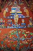 Wat Xieng Thong temple in Luang Prabang, Laos. Detail of the famous tree of life mosaic of the back wall of the sim, in colored glass on a dark red background. 